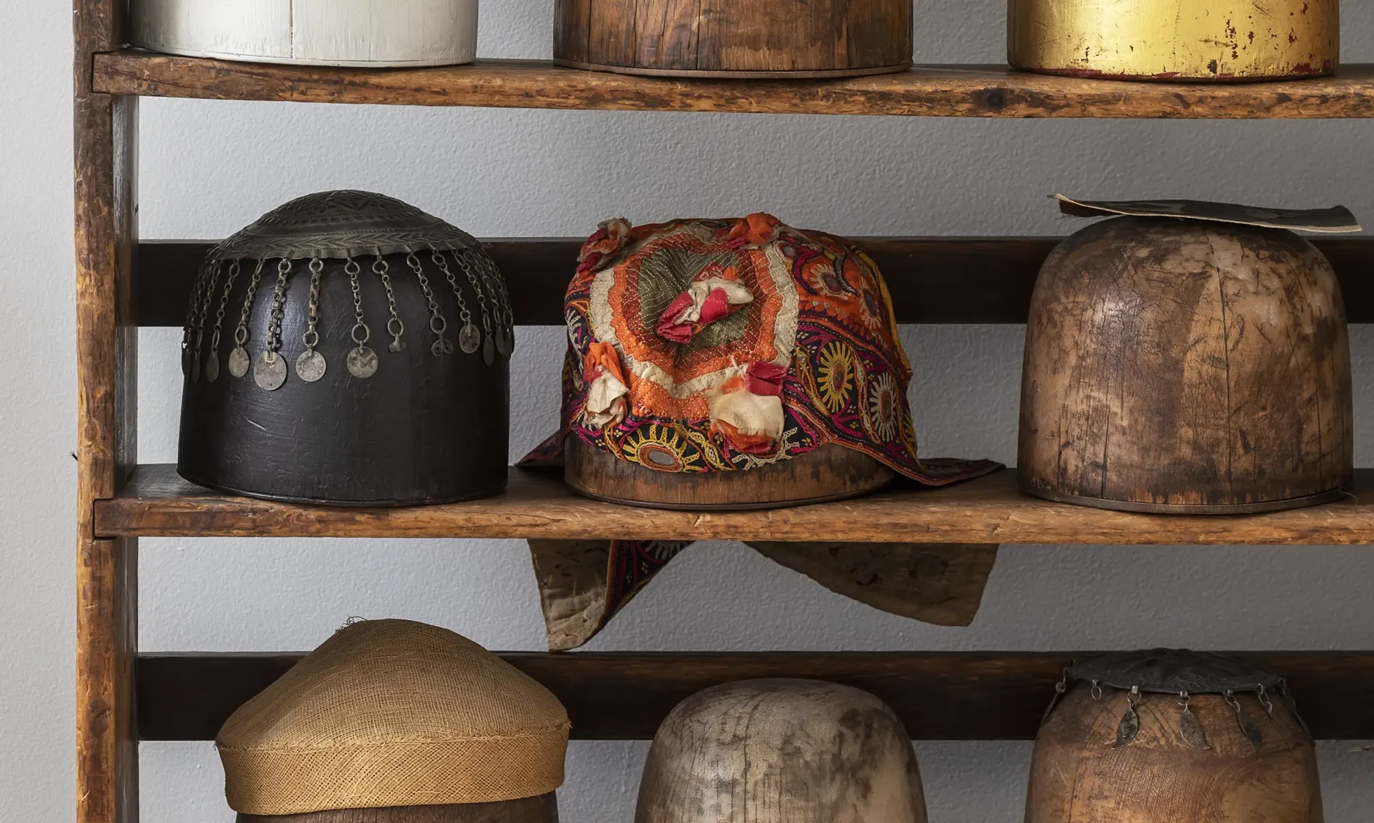 Shelf of head forms for different hats and headwear.