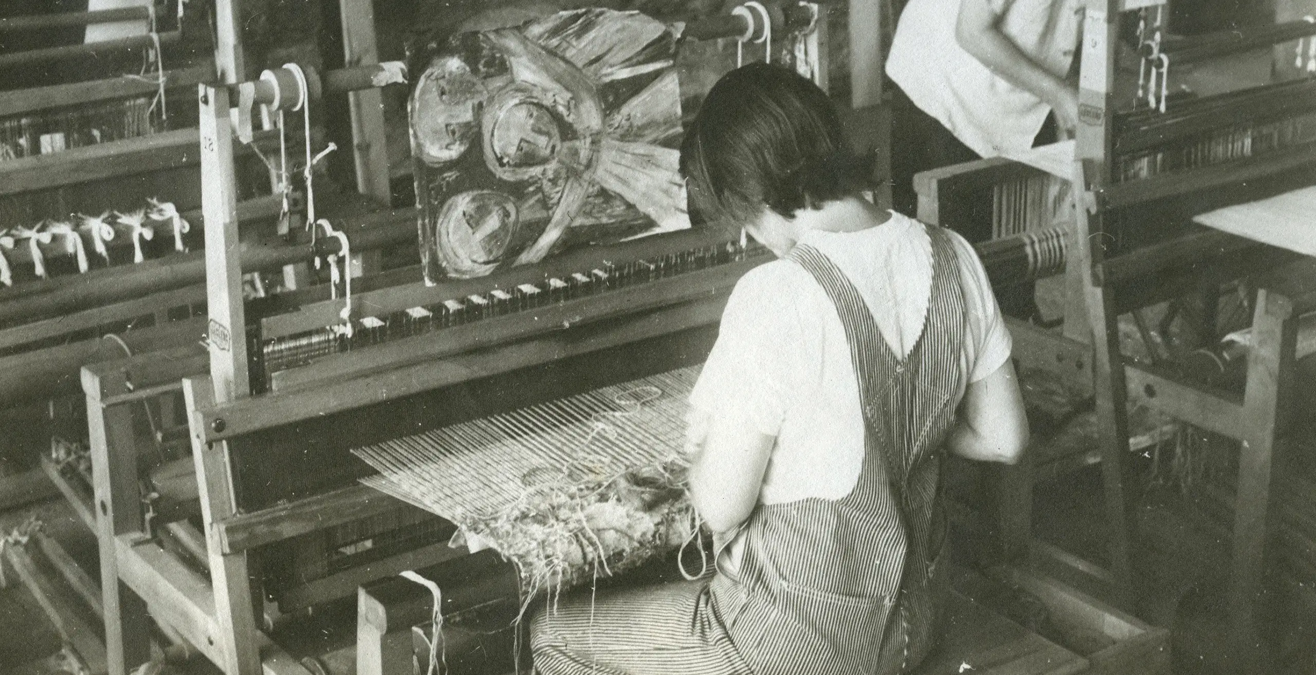 Old photograph of Lenore sitting at a weaving loom.